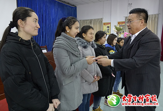 近日，新疆伊寧縣胡地亞于孜鎮(zhèn)蓋買村駐村工作隊(duì)干部郭曉慶（右）將助學(xué)經(jīng)費(fèi)發(fā)放到貧困大學(xué)生手中。鐘改清 閆 杰攝2.jpg